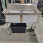 Two compartment sink with pump
